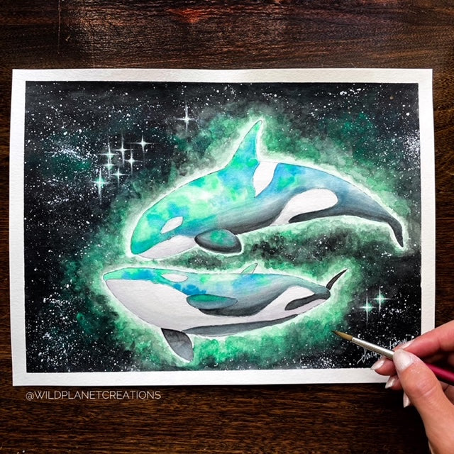 This image depicts the original watercolor painting of two orcas gliding through the cosmos (from the Wild Planet Creations collection).