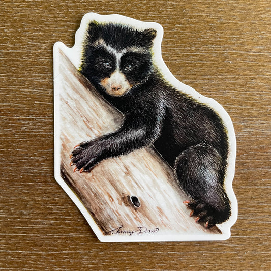 A close-up image of the waterproof, vinyl, dye-cut sticker depicting a watercolor painting from the Wild Planet Creations collection of an Andean bear cub.