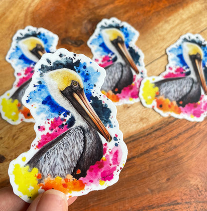 A close-up image of the waterproof, vinyl, dye-cut sticker depicting a watercolor painting from the Wild Planet Creations collection of a brown pelican.